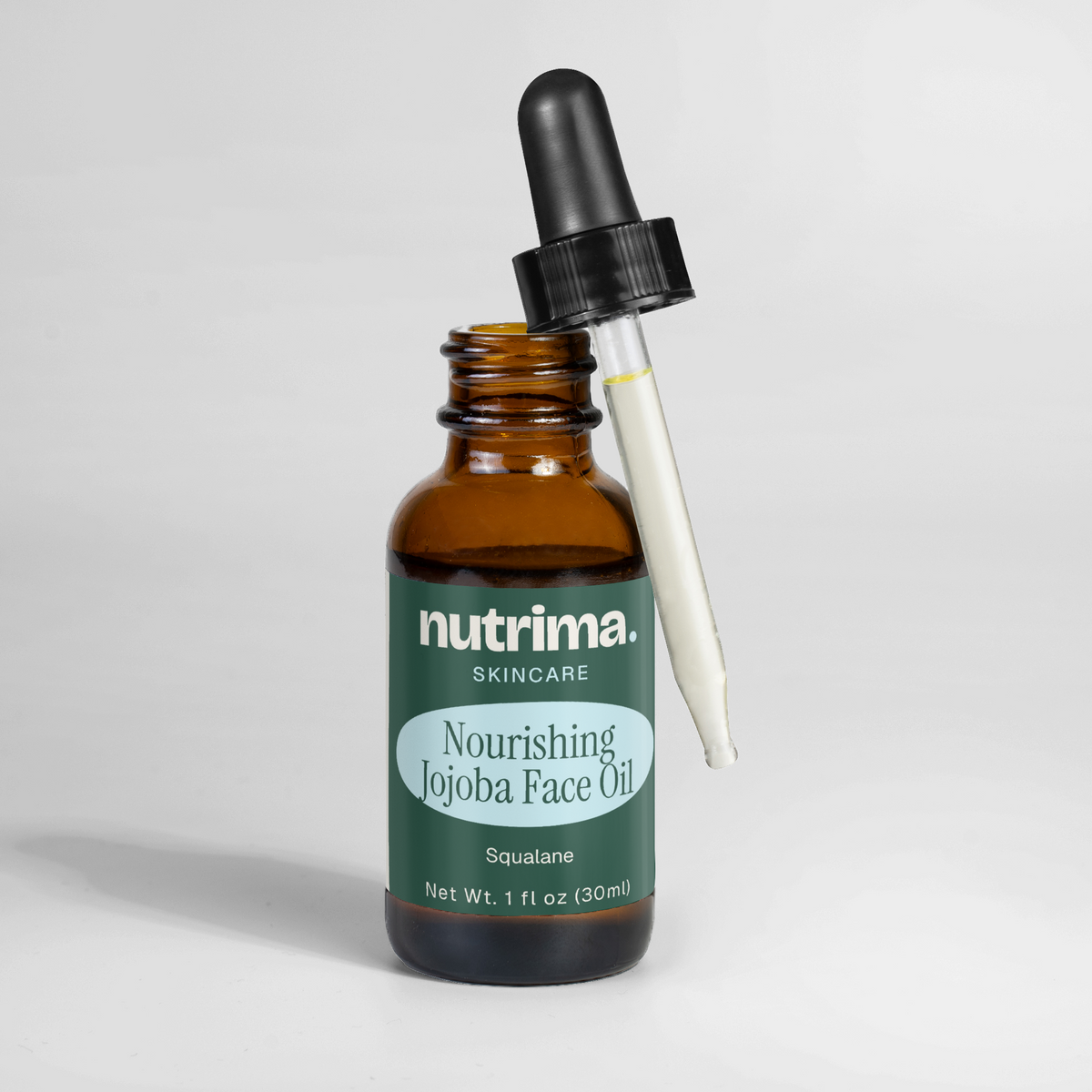 Amber glass bottle with a dropper featuring Nourishing Jojoba Face Oil by nutrima, showcasing its squalane content.