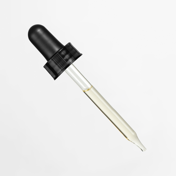 Clear dropper with black lid resting, containing Nourishing Jojoba Face Oil by nutrima.