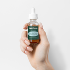 Hand holding a glass dropper bottle of Dark Spot Serum for Normal Skin by nutrima against a white background.