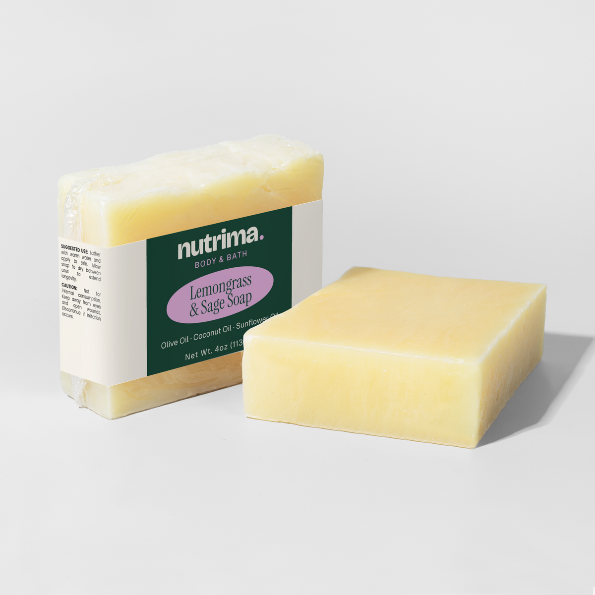 Lemongrass & Sage Soap, wrapped in clear film, showcases a creamy yellow block sitting beside its packaging by nutrima.
