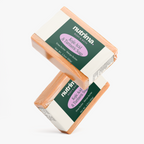 Two bars of Kojic Acid & Turmeric Soap in peach packaging, showcasing the product by nutrima.