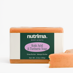 Kojic Acid & Turmeric Soap bar in a vibrant orange hue, showcasing a bite taken out, by nutrima.