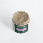 Top view of a jar of Dead Sea Mud with creamy texture and bold green and purple packaging by nutrima.