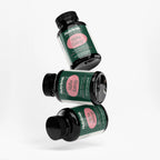 Three jars of Alpha Energy dietary capsules in a playful arrangement, showcasing their distinctive packaging by nutrima.