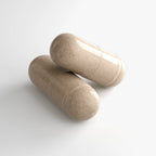 Two glossy, beige Ashwagandha Plus capsules on a white background, highlighting their smooth texture by nutrima.