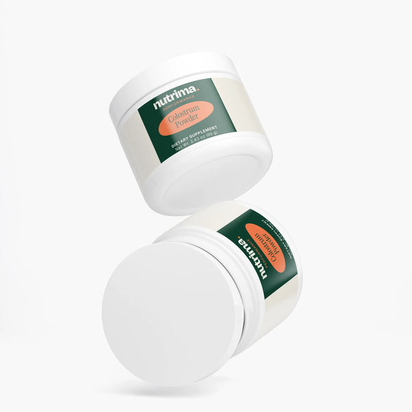 Two jars of Colostrum Powder, a dietary supplement by nutrima, shown in a dynamic angled view.