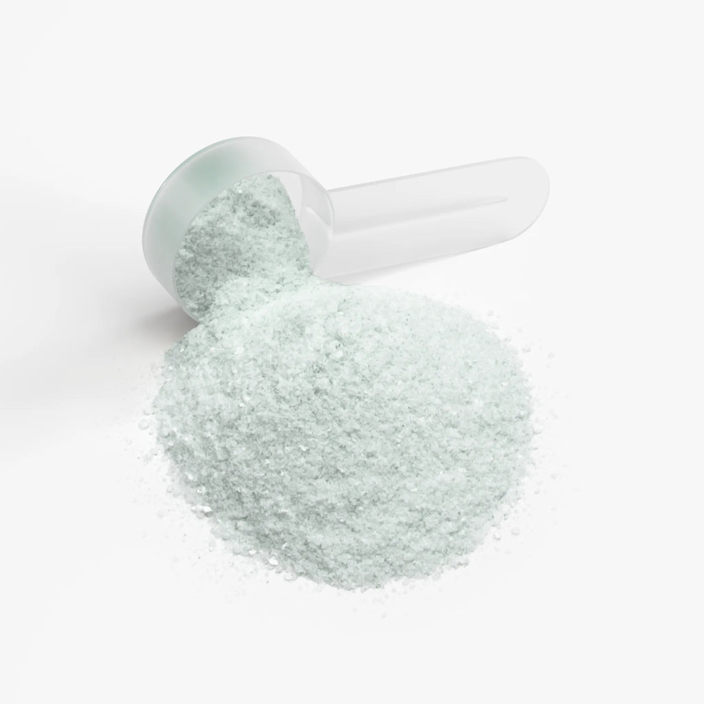 Light green Energy Powder (Melon Creamsicle) with a clear scoop, displayed in a pile on a white background by nutrima.