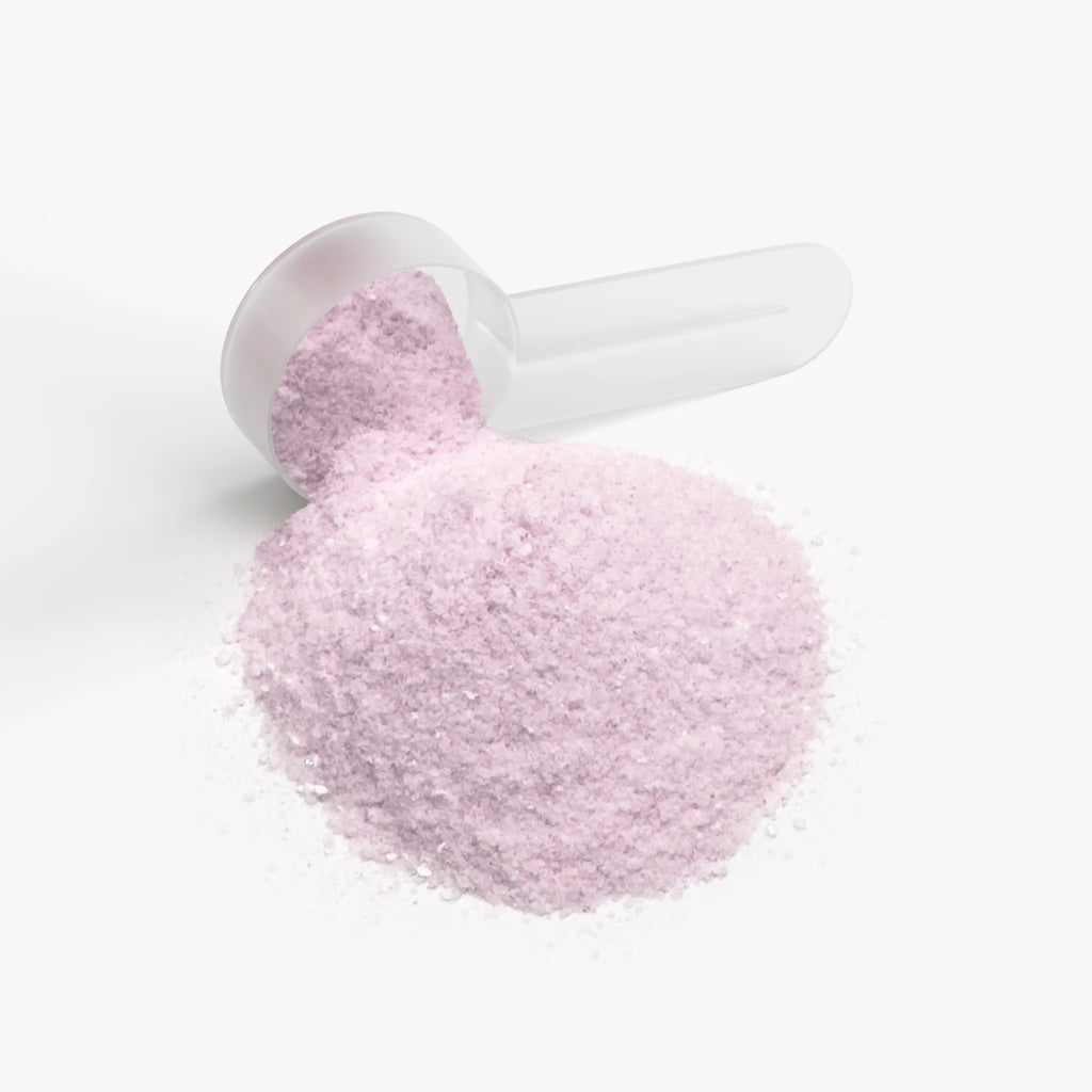 Pink powder spilled from a clear scoop, highlighting the Energy Powder (Strawberry Shortcake) by nutrima.