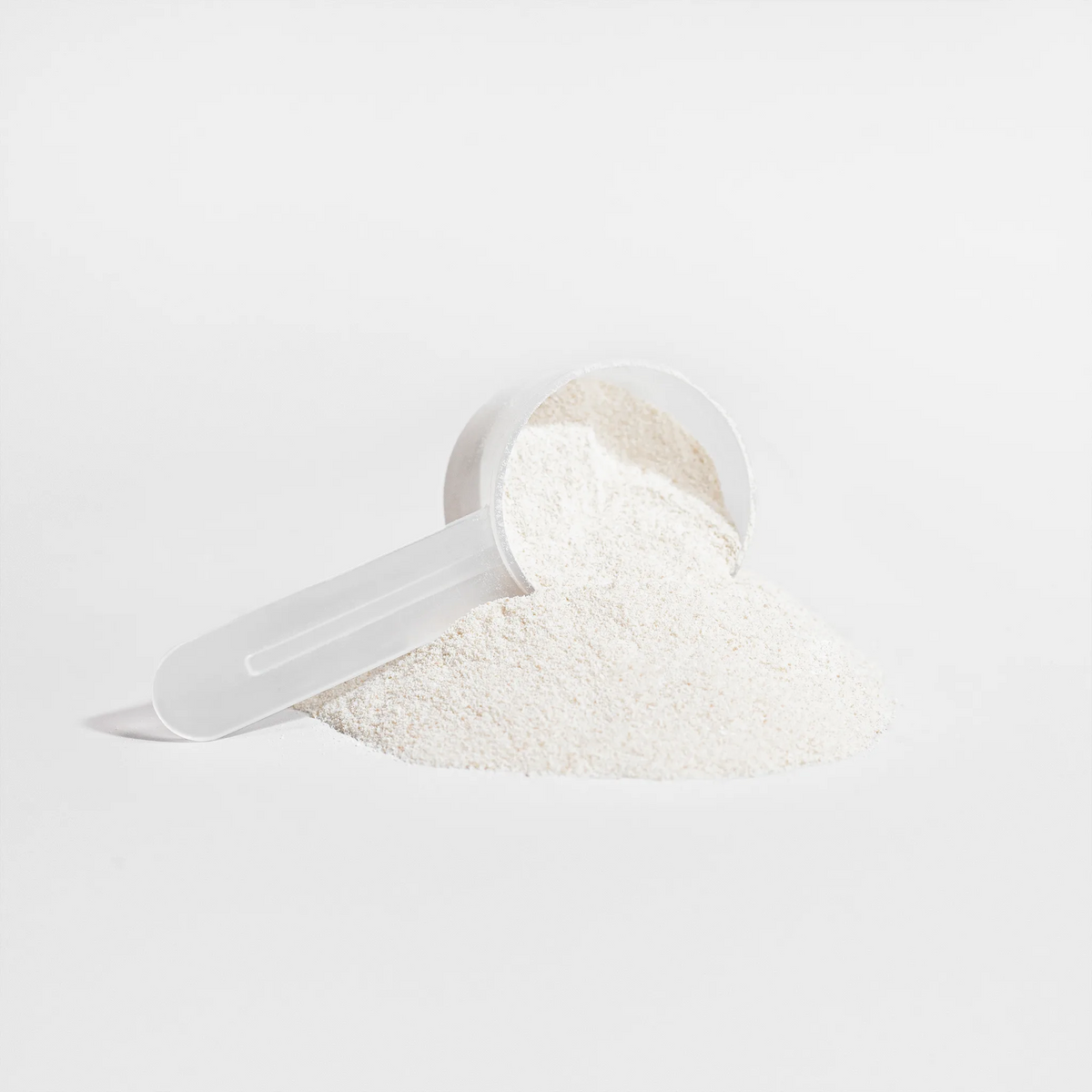 A scoop of fine white powder beside a mound, featuring Grass-Fed Collagen Creamer (Vanilla) by nutrima.