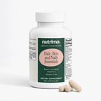 White bottle of Hair, Skin and Nails Essentials with label details, alongside three capsules, by nutrima.
