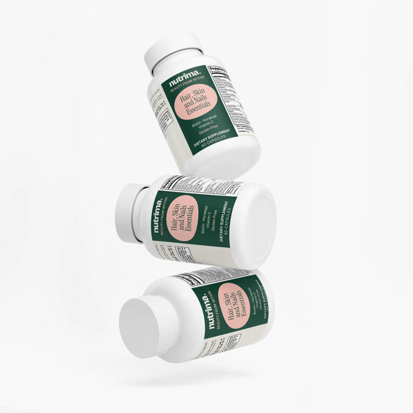 Three floating bottles of Hair, Skin and Nails Essentials by nutrima, showcasing a clean design and bright labels.