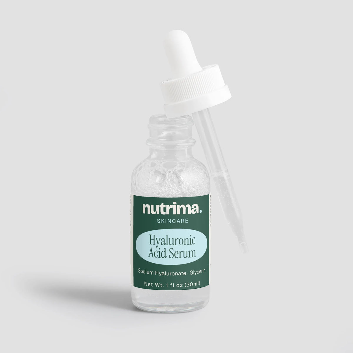 Clear glass bottle with a dropper and label for Hyaluronic Acid Serum by nutrima, showcasing the product’s purity and simplic