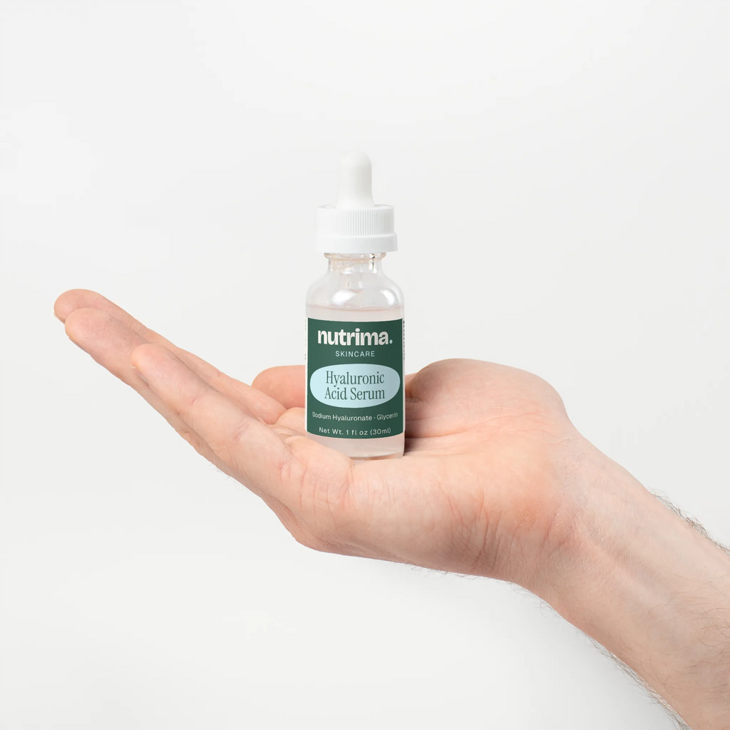 Hyaluronic Acid Serum held in a hand, showcasing its clear bottle and label details by nutrima.