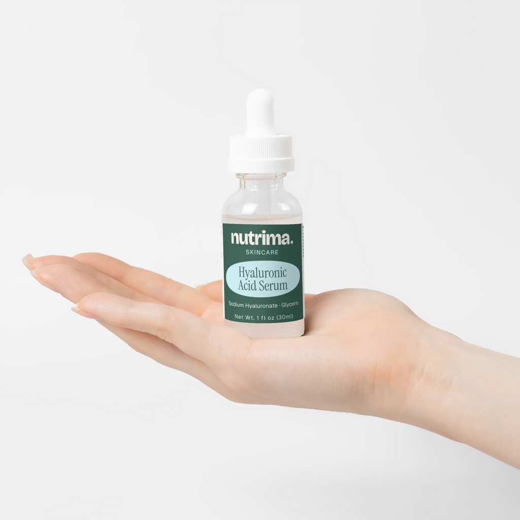 Hyaluronic Acid Serum displayed in a hand, highlighting the sleek packaging and serum's clear color, by nutrima.