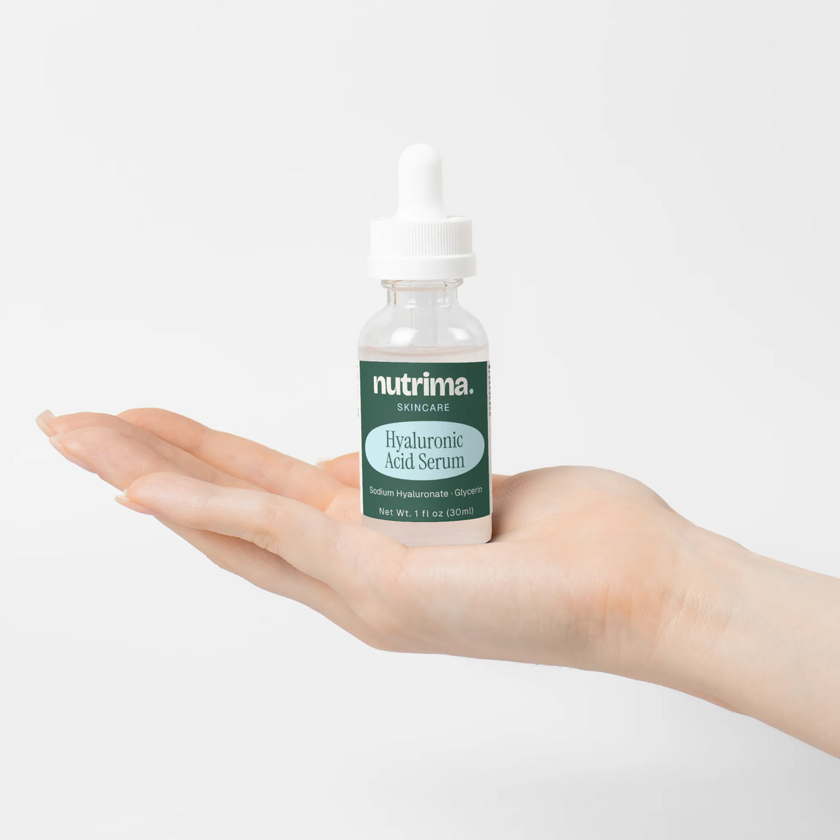 Hyaluronic Acid Serum displayed in a hand, highlighting the sleek packaging and serum's clear color, by nutrima.