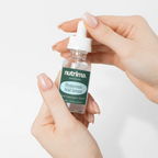 Hands holding a dropper bottle of Hyaluronic Acid Serum by nutrima, showcasing the clear liquid and elegant packaging.