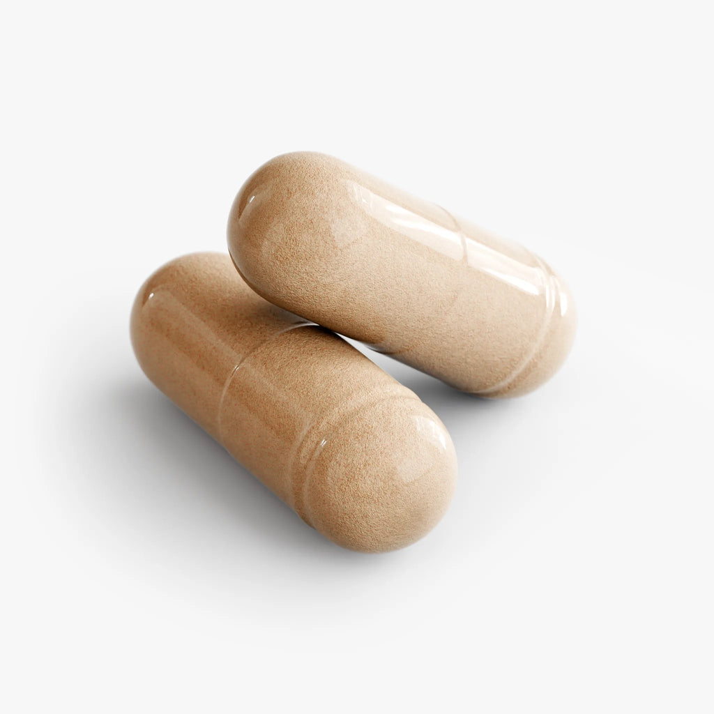 Two glossy, beige Mushroom Complex 10 X capsules are stacked together, showcasing their smooth texture by nutrima.