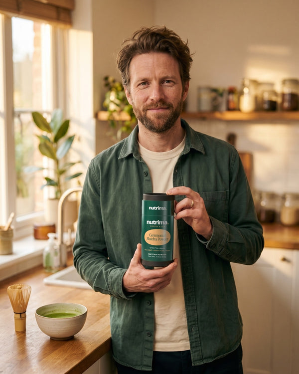 nutrima Ceremonial Matcha Powder tube held by a man at a kitchen counter beside a bowl of matcha — AI-generated brand image