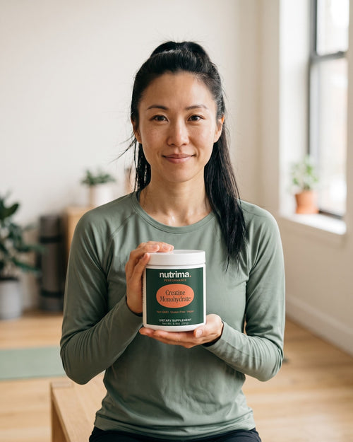 nutrima Creatine Monohydrate jar held by a woman in a home training room — AI-generated brand image