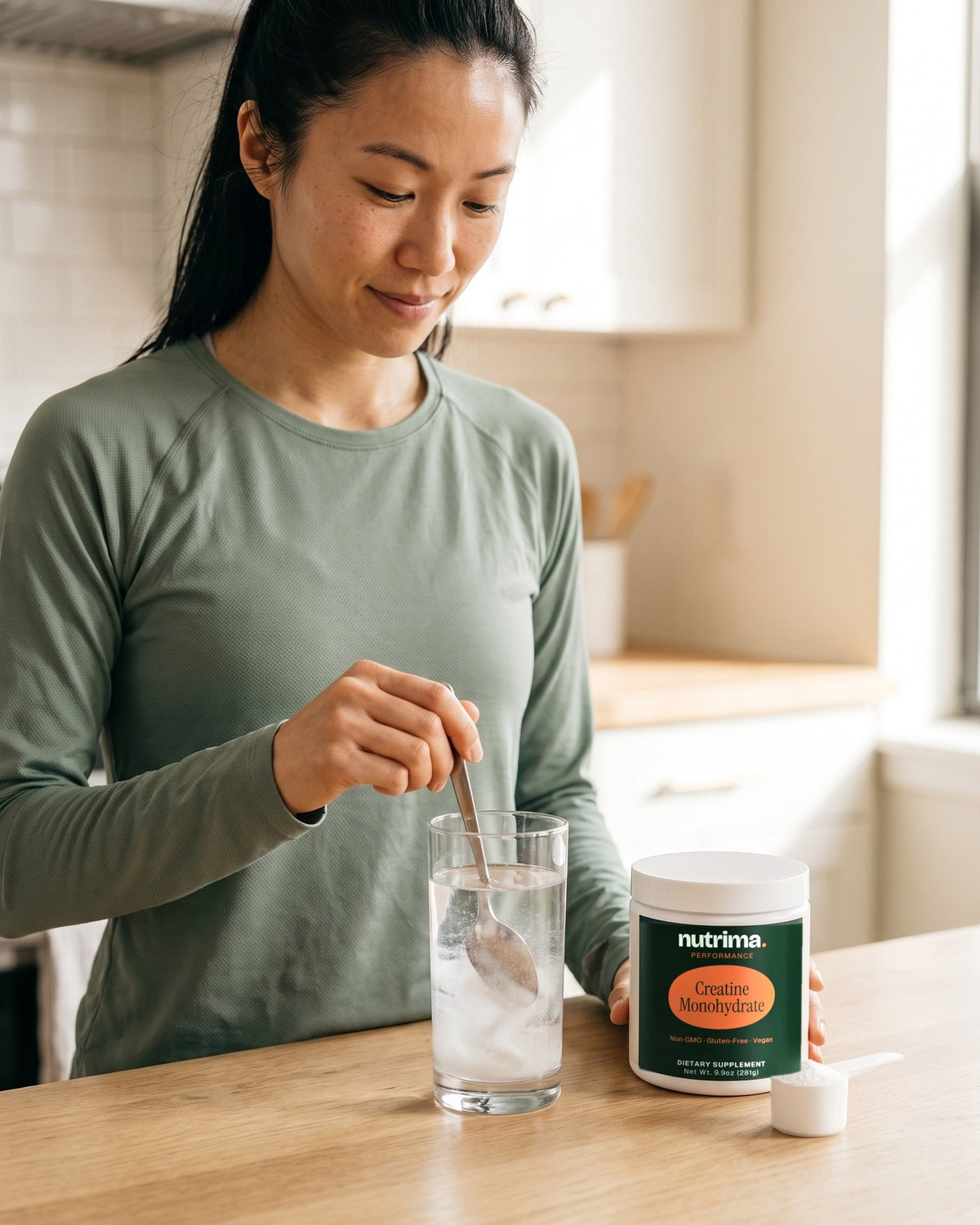 nutrima Creatine Monohydrate jar on a counter as a woman stirs powder into a glass of water — AI-generated brand image
