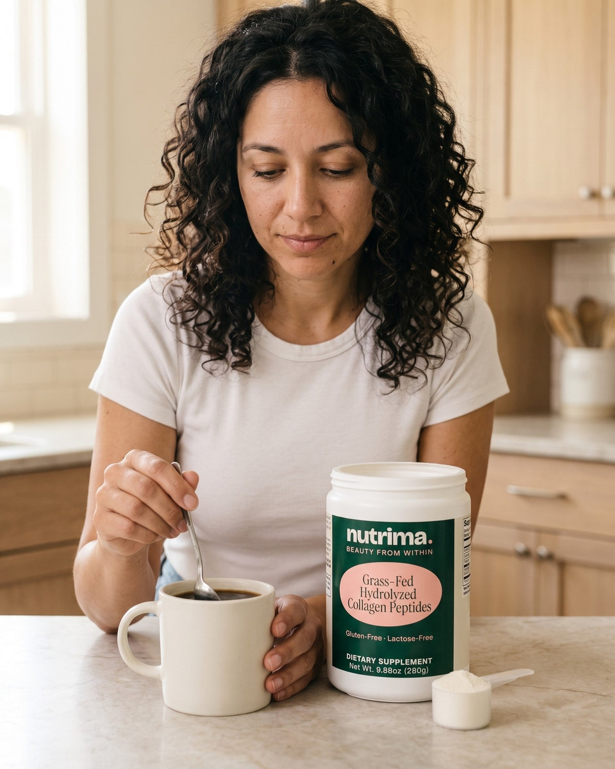 nutrima Grass-Fed Hydrolyzed Collagen Peptides tub on a counter as a woman stirs a mug of coffee — AI-generated brand image