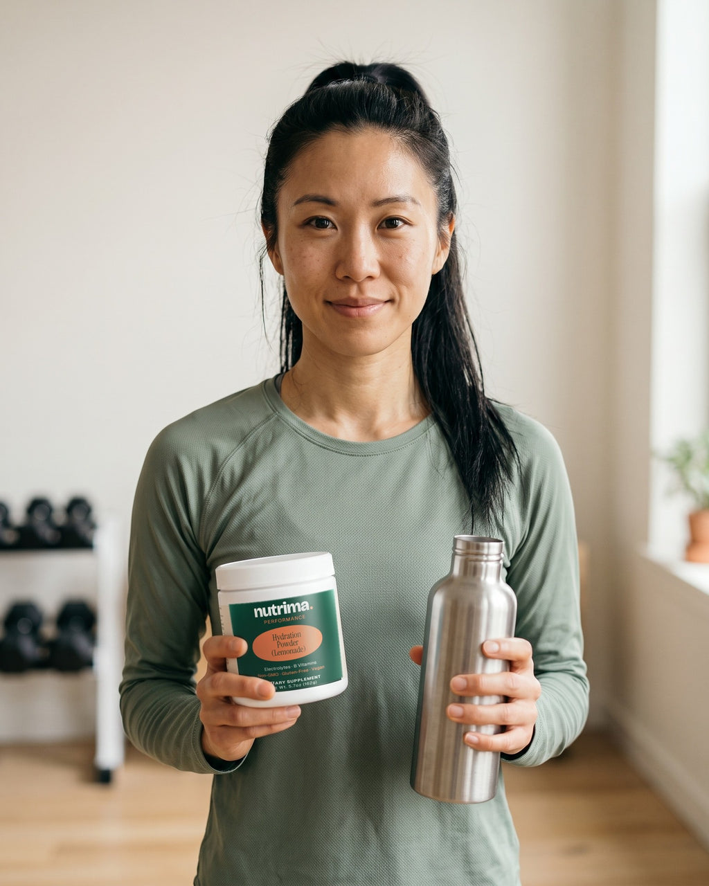 nutrima Hydration Powder (Lemonade) jar held by a woman in a home training room with a water bottle — AI-generated brand image