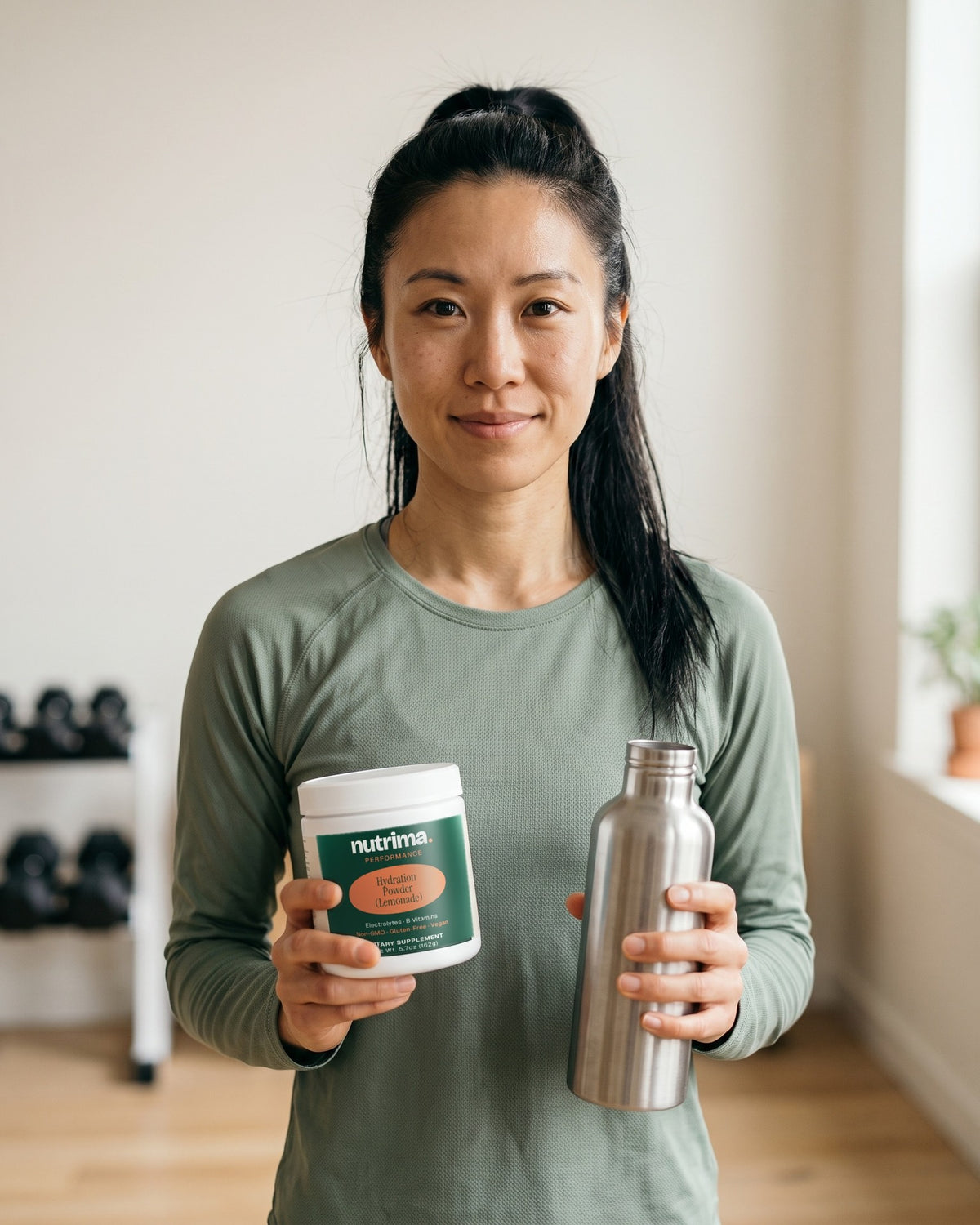 nutrima Hydration Powder (Lemonade) jar held by a woman in a home training room with a water bottle — AI-generated brand image