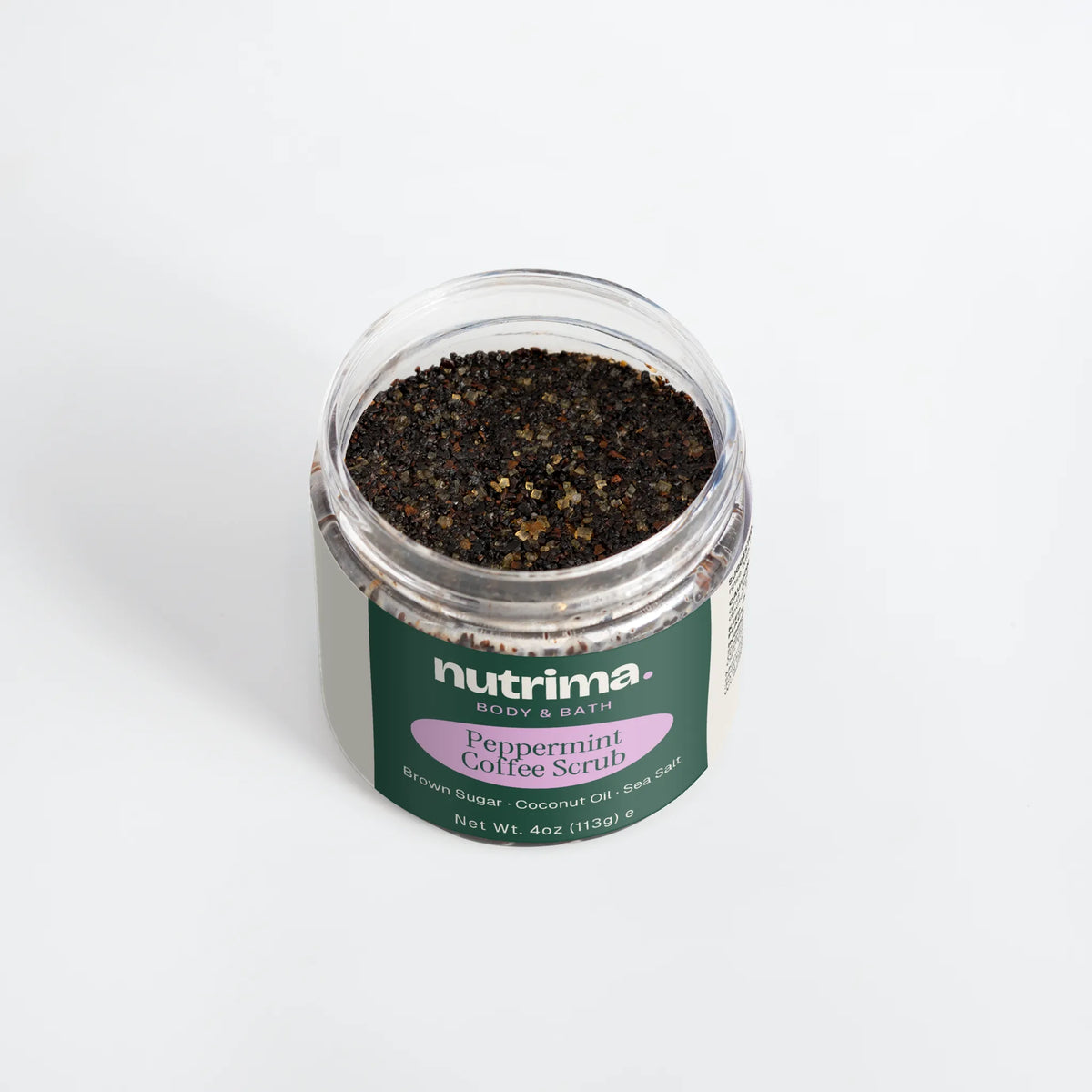 Close-up of Peppermint Coffee Scrub in a clear jar, showcasing the dark scrub mixture and colorful branding by nutrima.