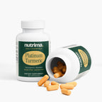 Platinum Turmeric capsules spill from an open bottle, highlighting the product's gluten-free label by nutrima.