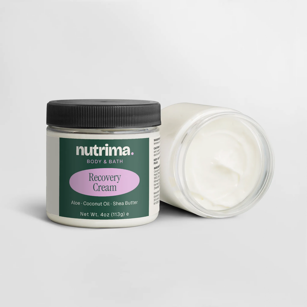 Recovery Cream in a clear jar with black lid, showcasing its smooth white texture, by nutrima.