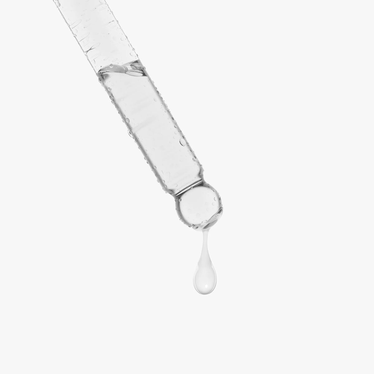 A drop of clear serum drips from a glass dropper, highlighting the Snail Mucin Face Serum by nutrima.
